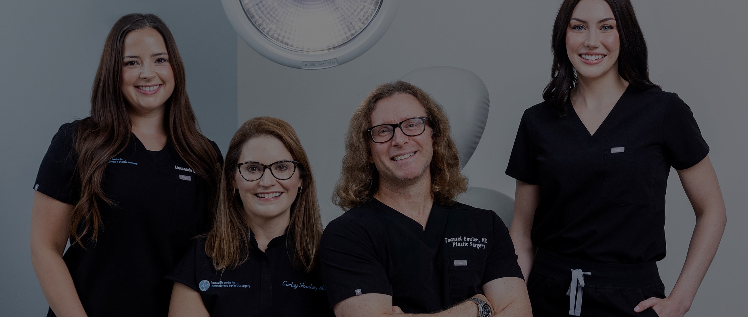Medical professionals posing together in clinic attire.