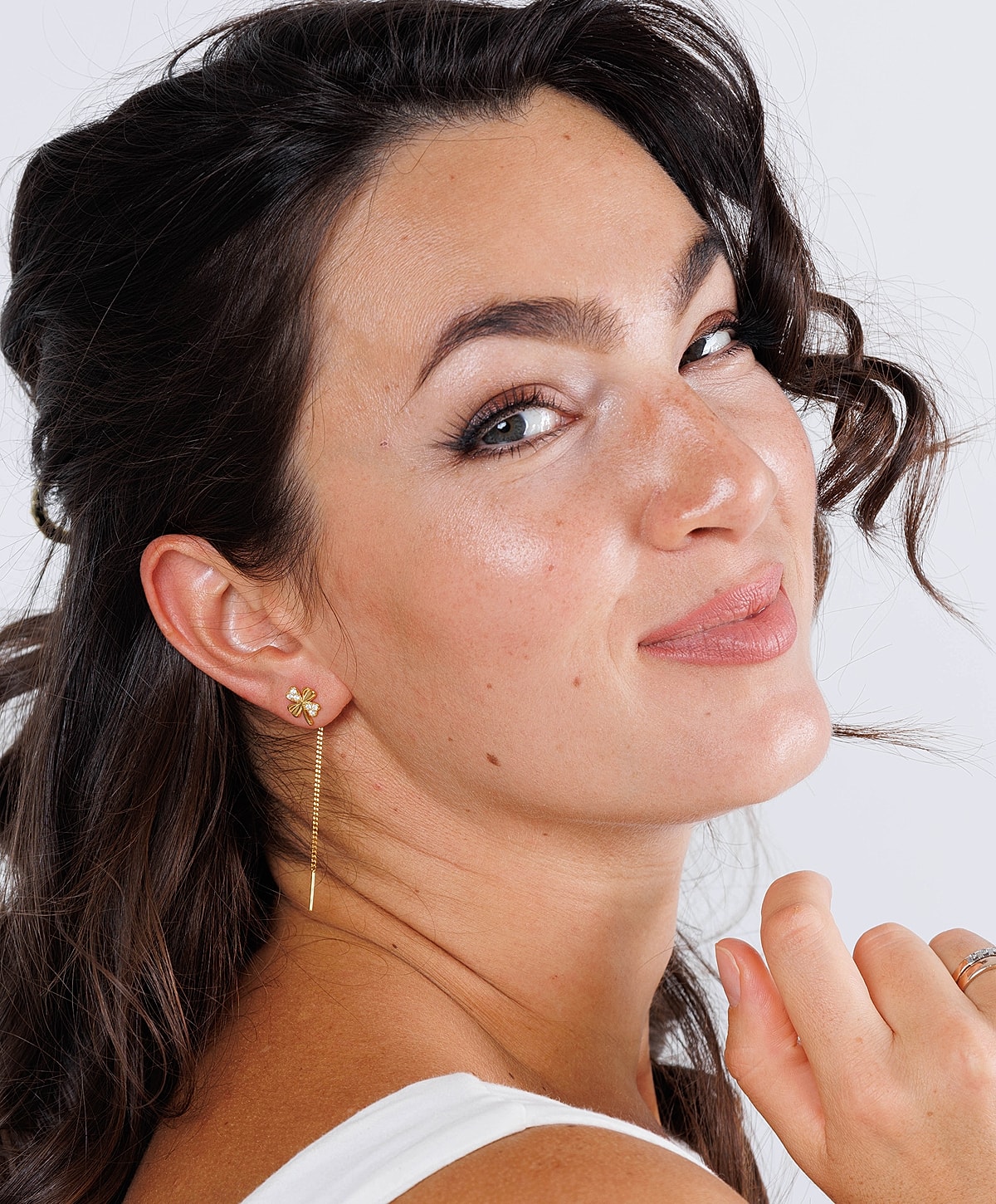 Smiling woman with stylish earrings and makeup.