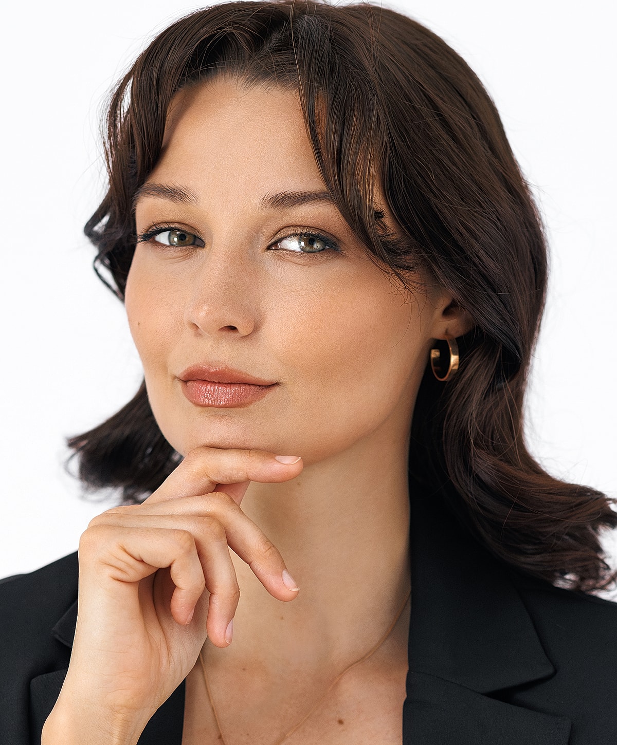 Woman posing thoughtfully in a black blazer.