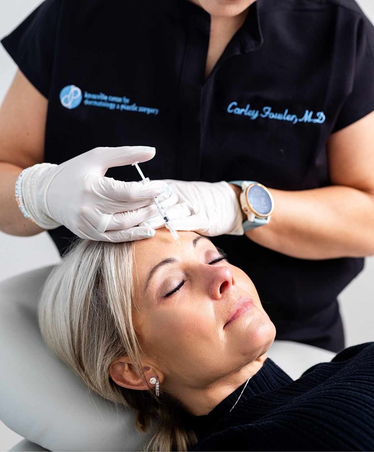 Injecting beauty treatment on woman's forehead.