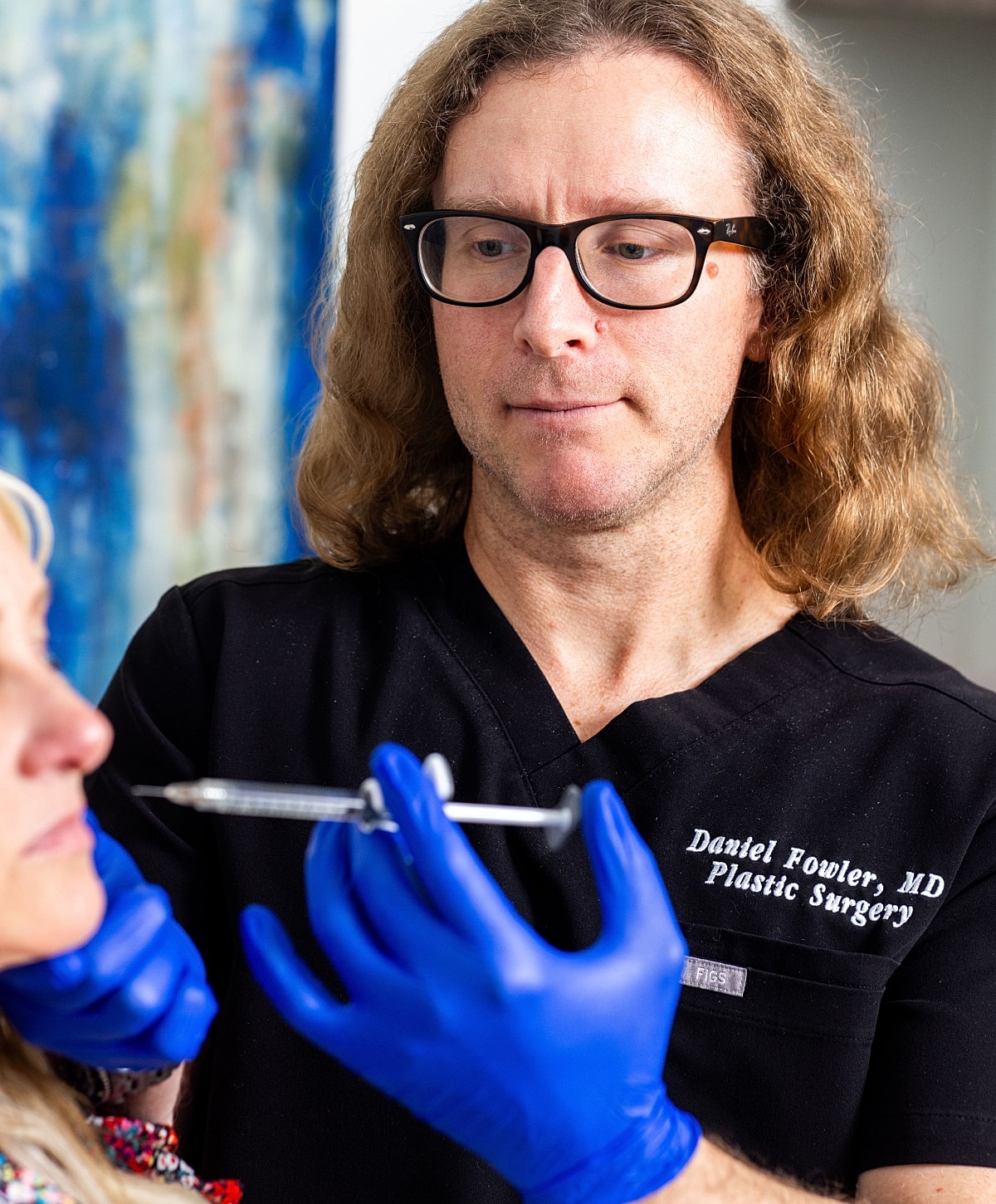 Woman receiving lip filler treatment in clinic.