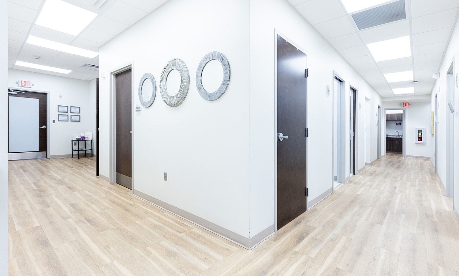 Modern hallway with decorative mirrors and doors.